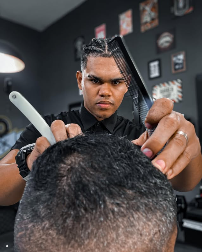 Barbeiro da Fernandez Barbershop trabalhando com precisão